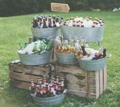 an assortment of beer bottles in buckets on the grass