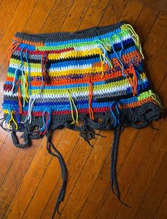 a multicolored crocheted bag laying on the floor