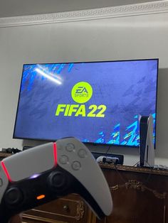 a video game controller sitting in front of a flat screen tv with the logo on it