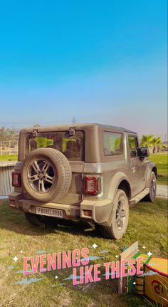 the back end of a truck parked on top of a lush green field