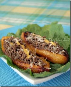 two hot dogs with toppings sit on a plate next to some lettuce