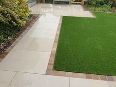 a small garden with grass and benches in the background