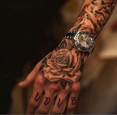 a person's hand with tattoos on it and a rose tattooed on the wrist