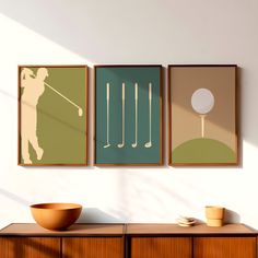 three framed golf images hang on the wall next to a bowl and wooden cabinet in a white room