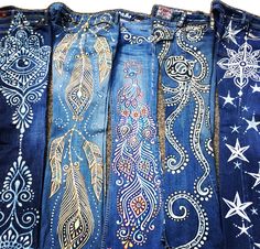 four pairs of jeans with different designs on them, all lined up in a row