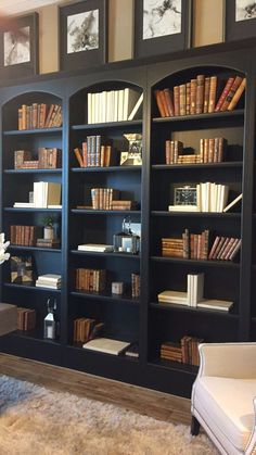 a living room filled with lots of bookshelves and furniture in front of them