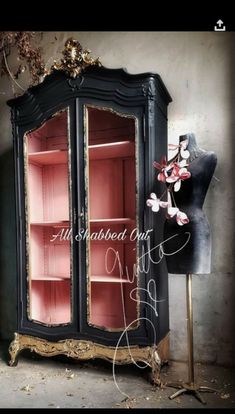 an old black china cabinet with pink glass doors