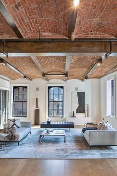 an open living room with exposed brick ceiling