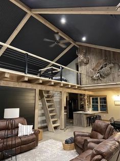 a living room filled with furniture and a loft style ceiling mounted to the side of a wall