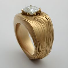 a gold ring with a white diamond on top