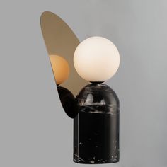 a black and white table lamp sitting on top of a wooden stand next to a mirror