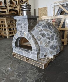 a stone oven sitting on pallets in a warehouse