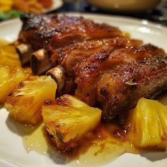 a white plate topped with meat and pineapples