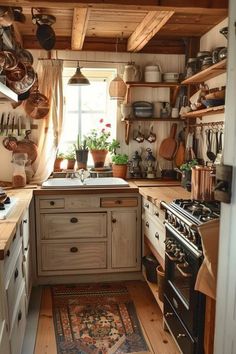 a kitchen with lots of pots and pans hanging from the ceiling above the stove