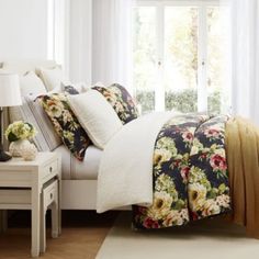 a bedroom with white walls and floral bedding