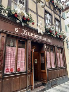 the front entrance to a restaurant with teddy bears on the windows and decorations hanging from the roof