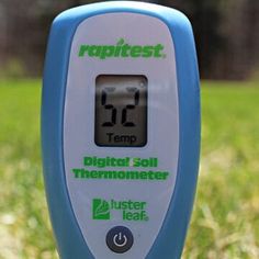 a digital thermometer sitting on top of a green field