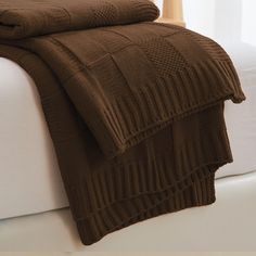 a bed with a brown blanket on top of it