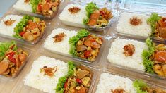 several plastic containers filled with food on top of a wooden table covered in rice and veggies