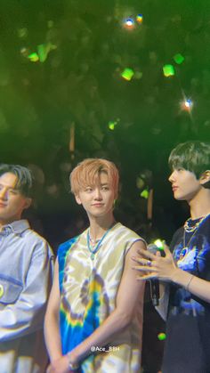 three young men standing next to each other in front of a green background with confetti