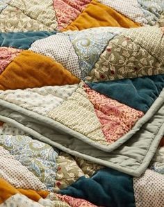 an old quilt is laying on top of the bedding and has been made into a blanket