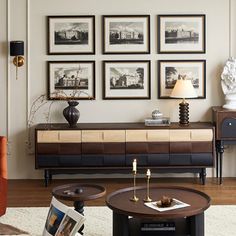 a living room filled with furniture and framed pictures on the wall above an end table