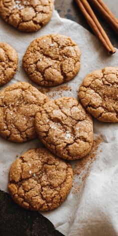 cookies and cinnamon sticks on top of paper