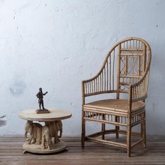 an elephant figurine sitting on top of a table next to a wooden chair