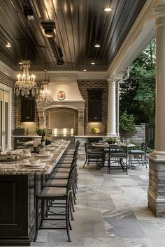 an outdoor kitchen and dining area is shown in this image, with dark wood paneling on the ceiling