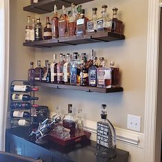 shelves filled with liquor bottles and glasses on top of a counter in a room next to a doorway