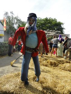 a man dressed up as a pirate holding a large ball in his hands while standing on some hay