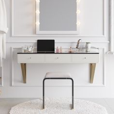 a desk with a mirror, stool and lights on it in front of a white wall