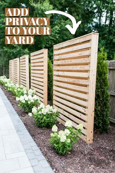 a wooden privacy fence with white flowers in the foreground and an ad for privacy to your yard