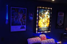 the movie poster on the wall is lit up with blue lights and there are two pillows in front of it