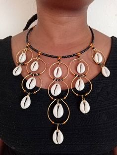 A Set of  African Cowrie Jewelry, Handmade Necklace, Seashell Jewelry, Boho Necklace, One size fits all, Pendant Necklace, EarringsThis set of jewelry is made of brass and cowrie seashell. It will make you stand out in any occasion.Necklace can fit any neck size..This can be a perfect gift for your loved ones. The price is inclusive of one necklace and a pair of matching earrings.We offer wholesale at a fair price,please contact me.***Free shipping on additional items in your cart.*** ***For mor African Cowrie Shell Jewelry, Shell Jewelry For Jewelry Making, Traditional Adjustable Shell Jewelry, Cowrie Shell Dangle Jewelry For Gifts, Cowrie Shell Dangle Jewelry Gift, Black Shell Bohemian Jewelry, Black Shell Jewelry For Gifts, Handmade Black Shell Jewelry, Handmade Black Shell-shaped Jewelry