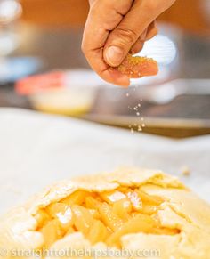 a person sprinkling salt on top of a pastry