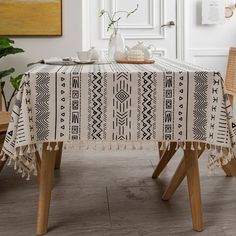 a table with a black and white pattern on it, next to two wooden chairs