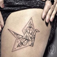 a woman's thigh with an origami tattoo design on the side,