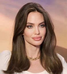 a woman with long brown hair wearing a white shirt and gold choker on her neck