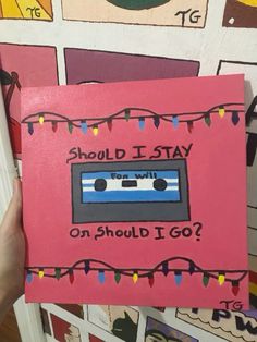 a hand holding up a pink card with an old school cassette on it that says should i stay on should i go?