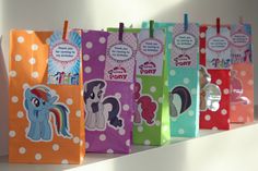 several little pony bags are lined up on a white shelf with polka dotty paper