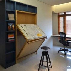 an open book shelf in the middle of a room with a desk and chair next to it