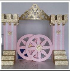 a pink and gold gate with a crown on it's head, sitting in front of a white wall