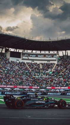 a race car driving down the track in front of an audience at a sporting event