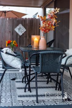 an outdoor table and chairs with candles on it