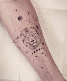 a man's arm with a lion and planets tattoo on the left inner forearm