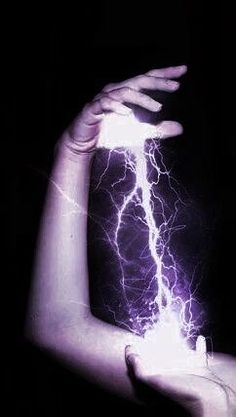 a woman's arm with lightning in the dark