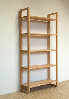 an empty wooden shelf against a white wall in a room with hardwood floors and hard wood flooring