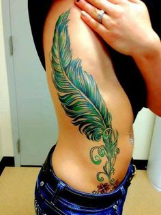 a woman's back with a tattoo on her stomach and a feather in the middle