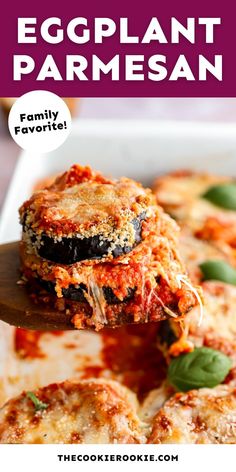 an eggplant parmesan is being lifted from a casserole dish